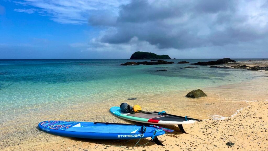 石垣島北部のビーチに置かれたSUPボードと迫る暗い雲