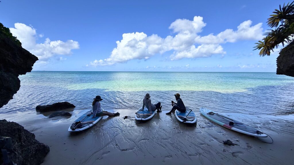 石垣島北部の静かな海でSUPボードに座りゆっくり過ごすゲストたち